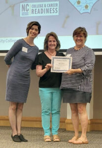 Leigh Davidson and Wendy Hicks, two of NC’s SIA Trainers, glowing with pride as they hand Laurie Weston, PDF for Beaufort County Community College, her Standards-in-Action Certificate.